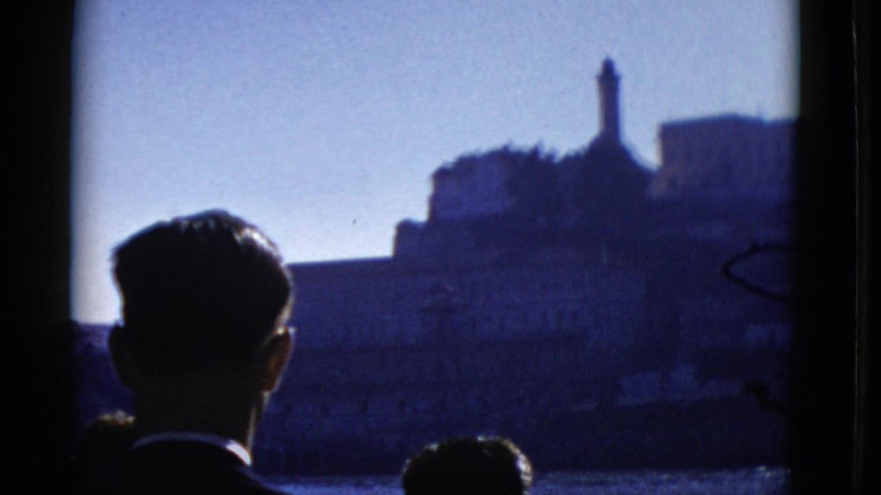 A passenger silhouette faces Alcatraz Island across the water.