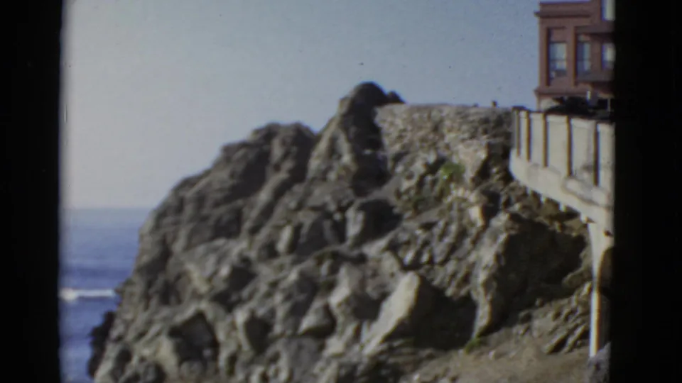 A handheld 1952 San Francisco view shows the stone overlook and rugged coastal rocks, with the ocean visible beyond the cliff.