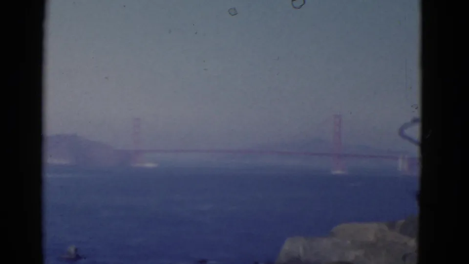 1952 San Francisco 8mm frame with the Golden Gate Bridge in the distance and small boats crossing the blue bay.