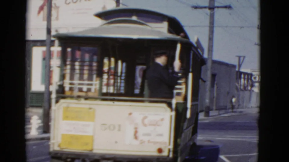 A San Francisco cable car marked 501 is seen from behind, with a uniformed operator or conductor standing at the rear.
