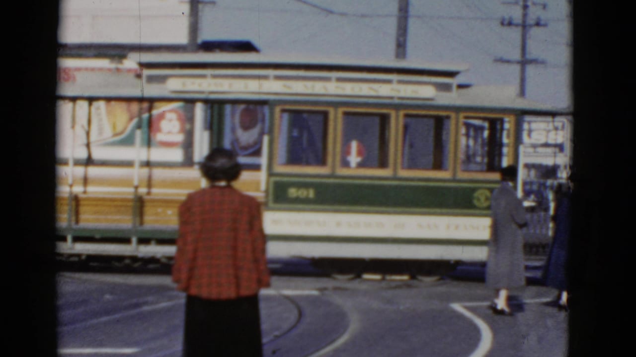 Rail car number 501 beside pedestrians, with a woman in a red plaid jacket in the foreground.