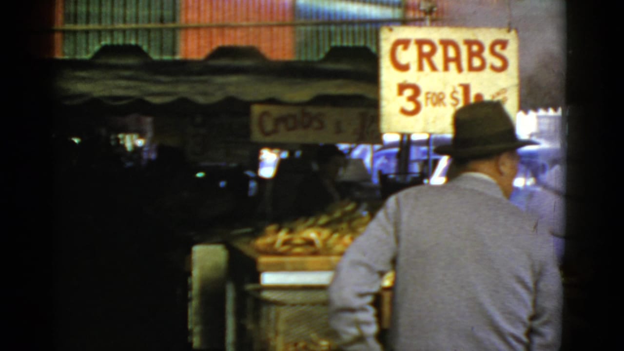 Man seen from behind near a crab vendor sign and seafood display.