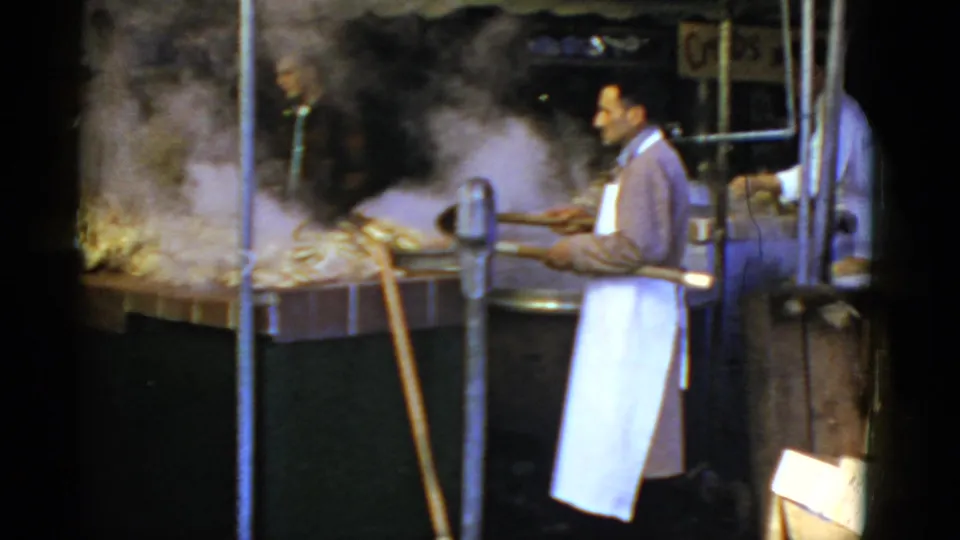Aproned vendor at a San Francisco crab stall tends steaming cooking equipment beside an open market counter.