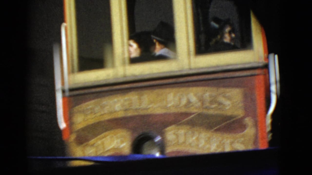 Close side view of a cable car with passengers visible through the windows.