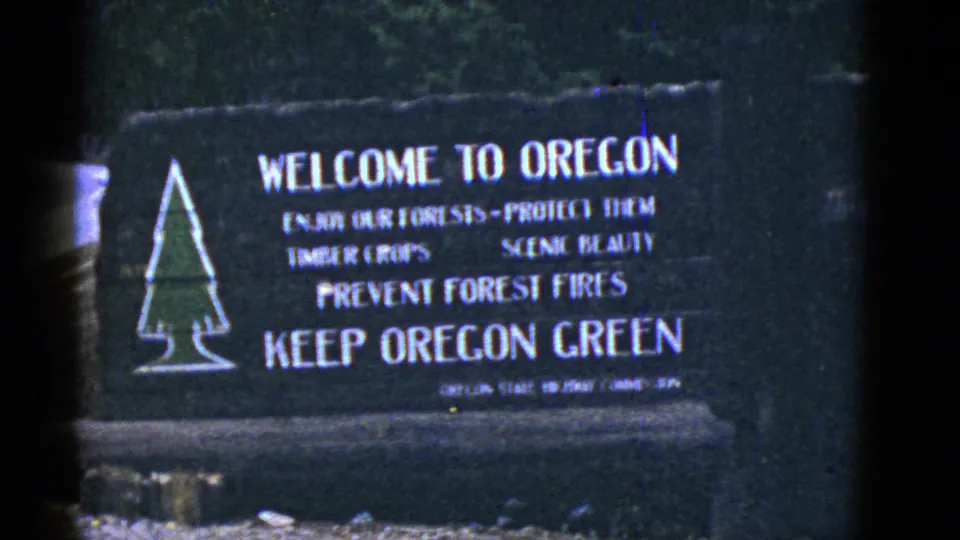 Final 8mm frame showing the Oregon welcome sign, conservation wording, and slight film-edge shadow.