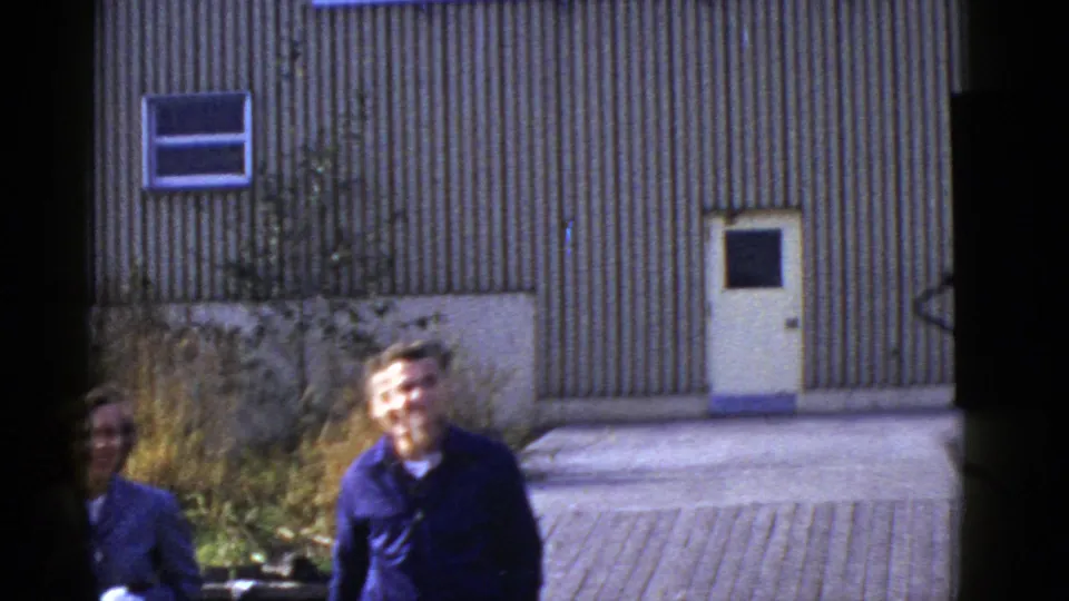 Early 1950s San Francisco frame with the man smiling near center and the woman partly hidden at the edge.