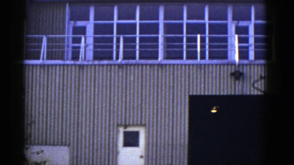 1950s San Francisco frame of a quiet corrugated facade with upper window bays, balcony railings, and lower entrances.