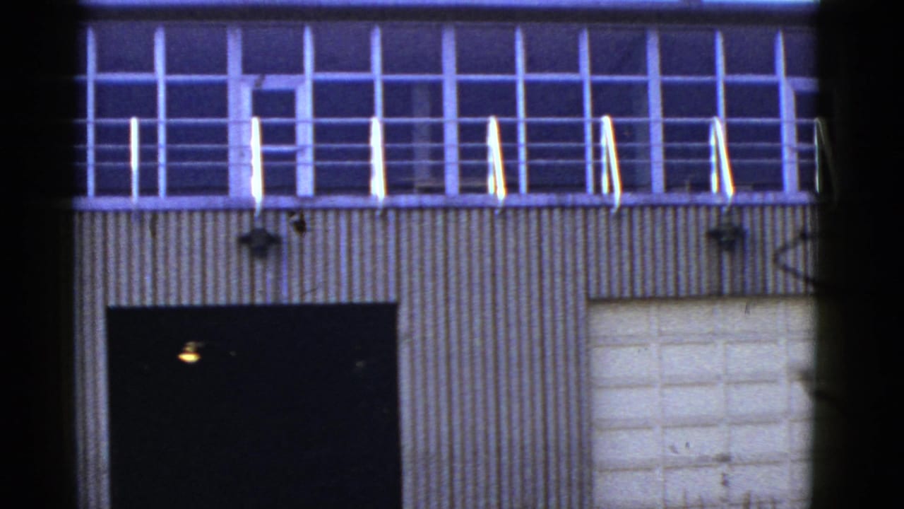 1950s San Francisco industrial building exterior showing upper grid windows, railing, corrugated wall panels, and large doors.