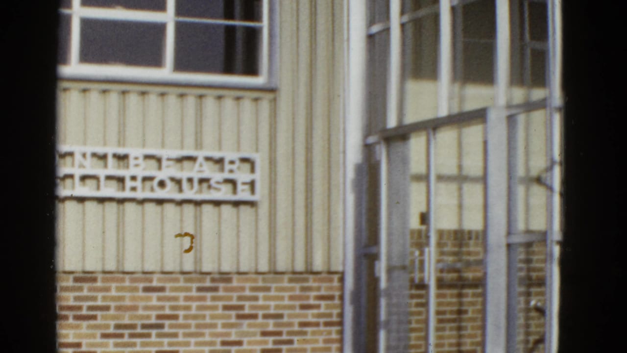 Exterior wall sign beside a glass-paned entrance with metal framing.