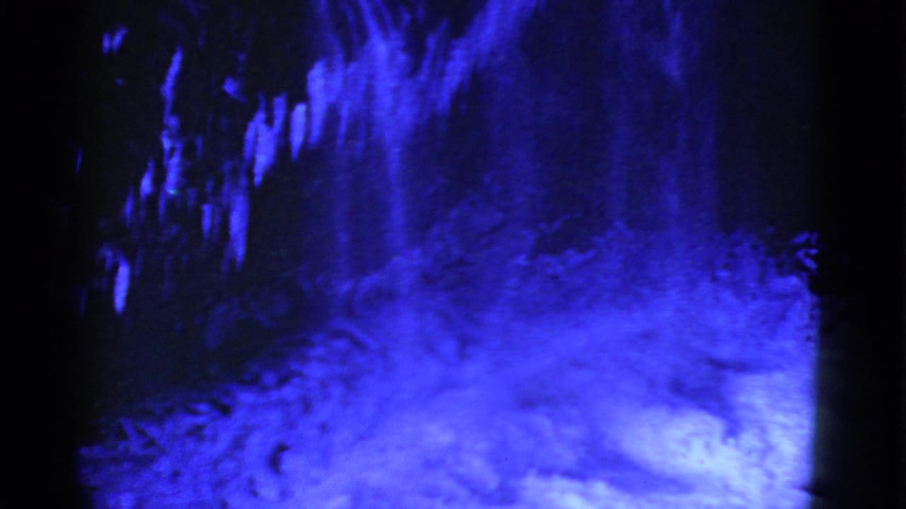 Blue snowy landscape with dark upper edge and sloped snowfield.