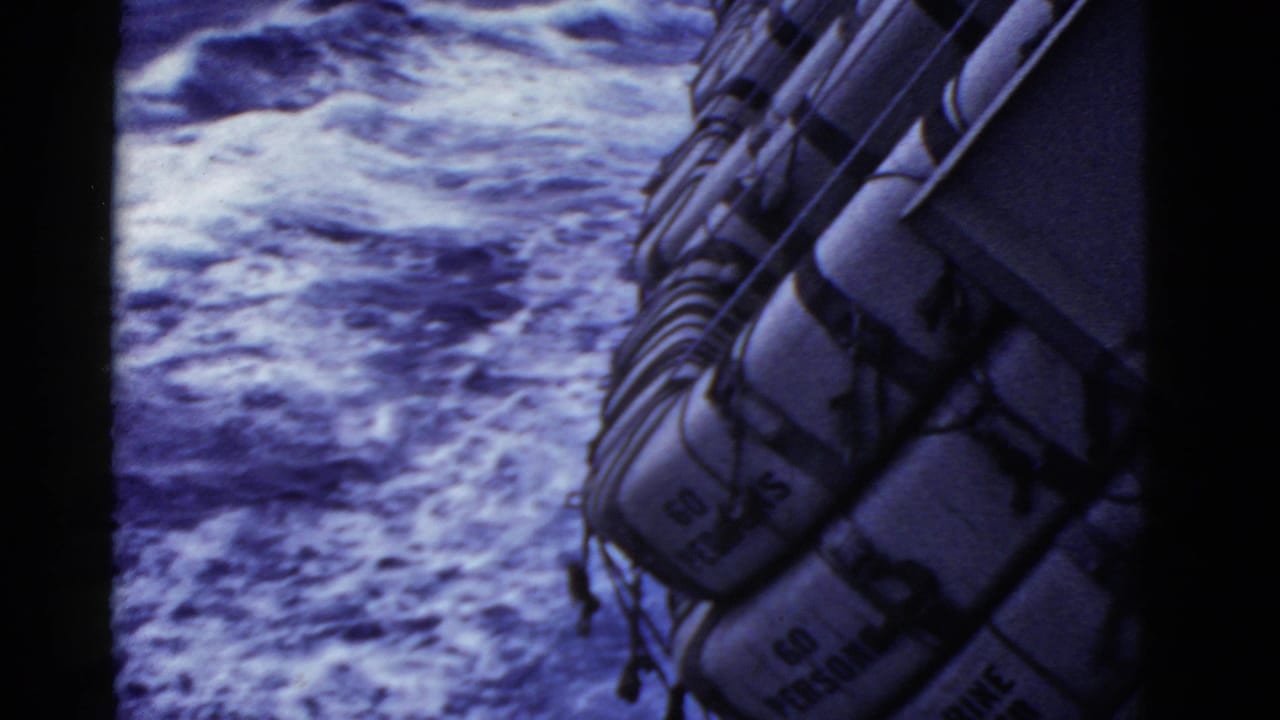 Life rafts along a ship rail above foamy ocean water.