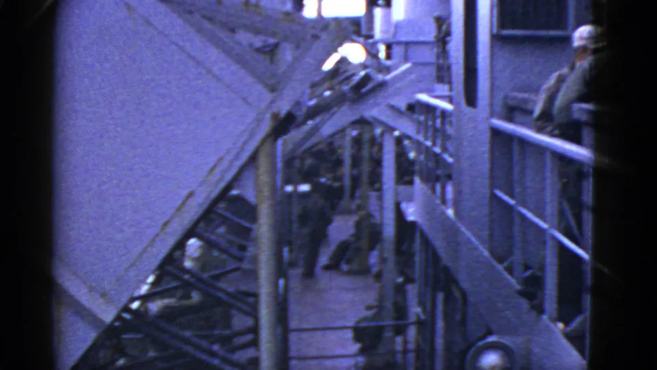 1950s 8mm view of a Navy ship deck near San Francisco, with sailors gathered around railings and stair structures.