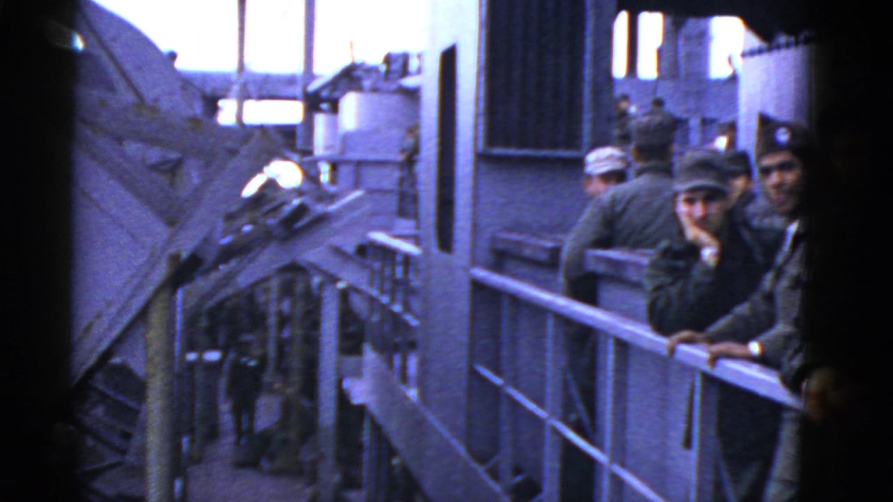 Men in military-style clothing lean near railings on a ship deck.