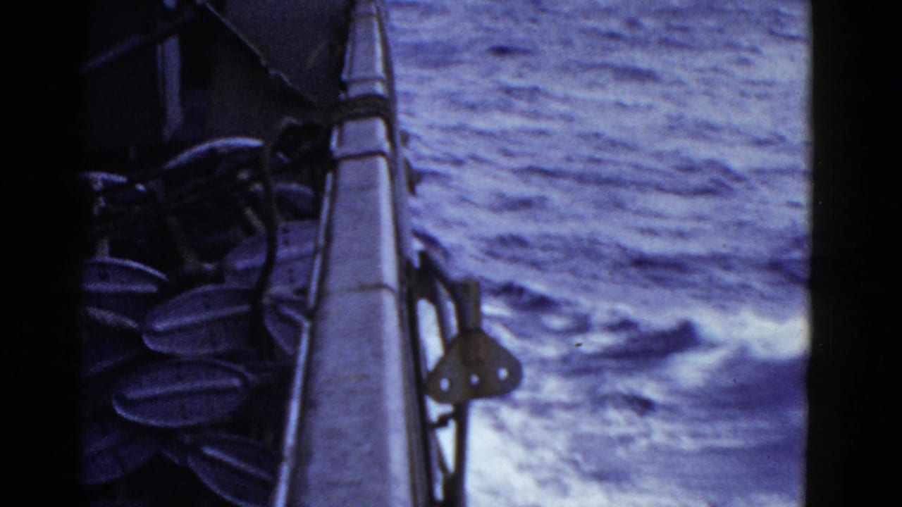 1952 8mm home-movie frame from the San Francisco reel showing a ship rail, deck hardware, and blue ocean wake beside the vessel.