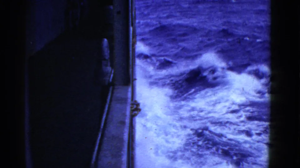 The ship side remains at left while blue-white ocean foam churns below in this 1952 8mm travel frame.