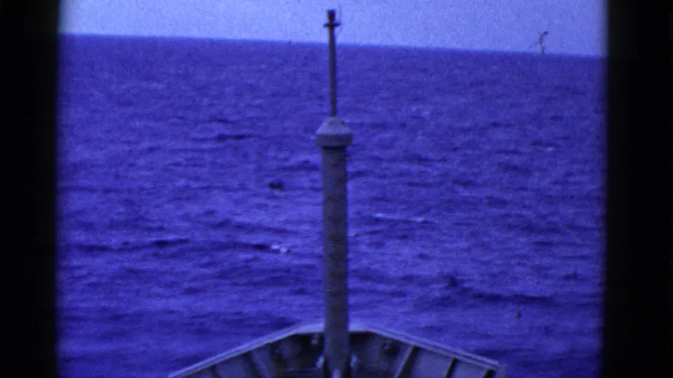 1950s 8mm shipboard view near San Francisco, looking past a central mast and bow toward blue open water.