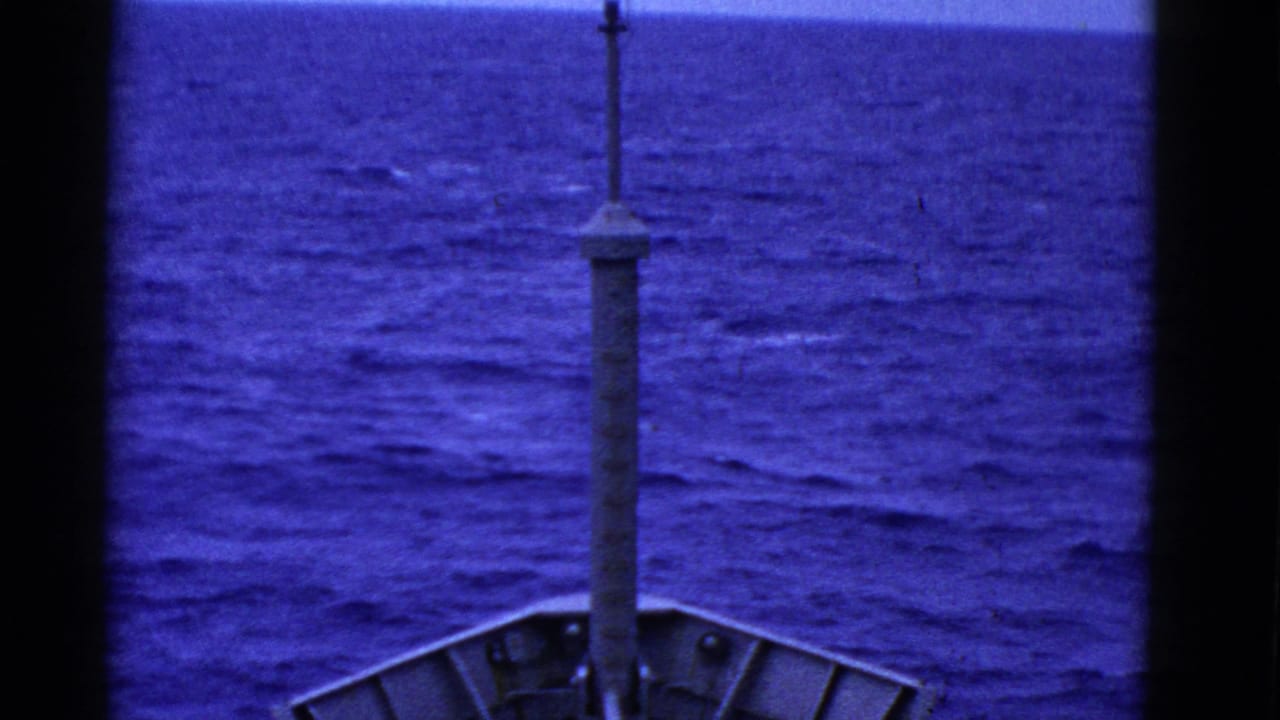 Blue-tinted 8mm frame of a ship bow and mast with rolling ocean ahead, consistent with the clip's San Francisco maritime metadata.