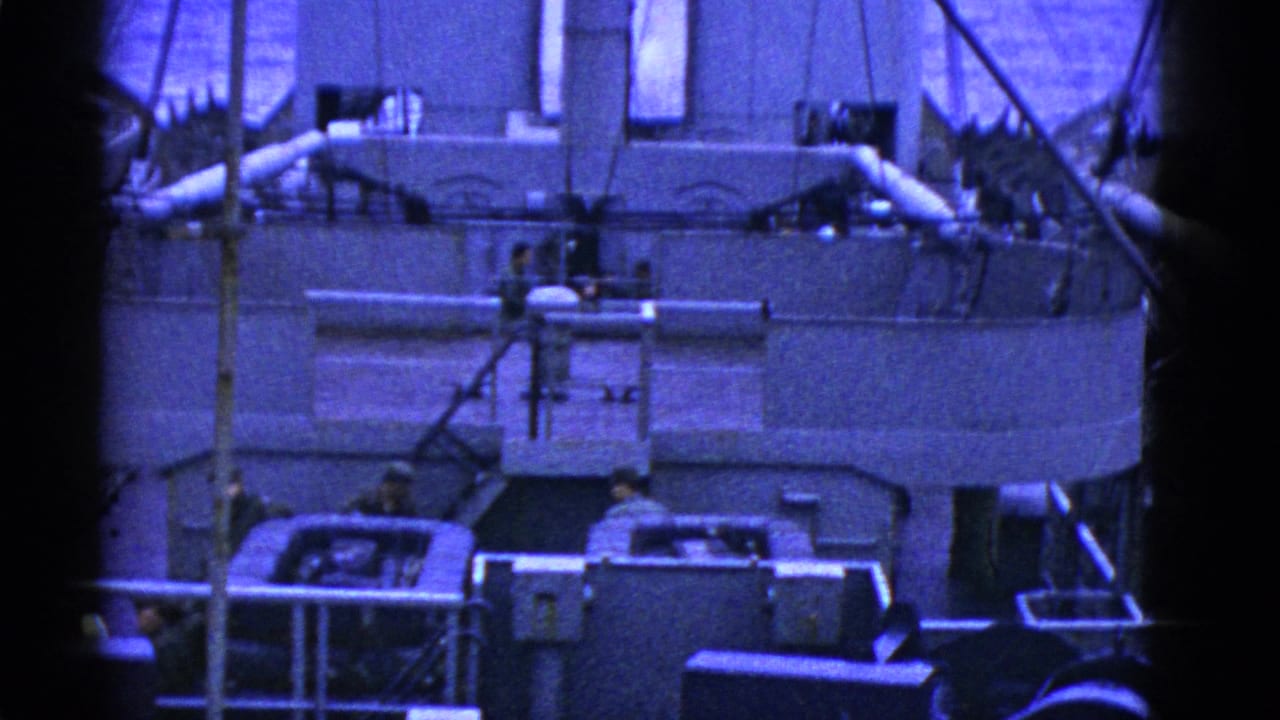 1950s San Francisco naval or maritime deck scene showing crew near large machinery, railings, pipes, and ship structures in blue-tinted 8mm film.