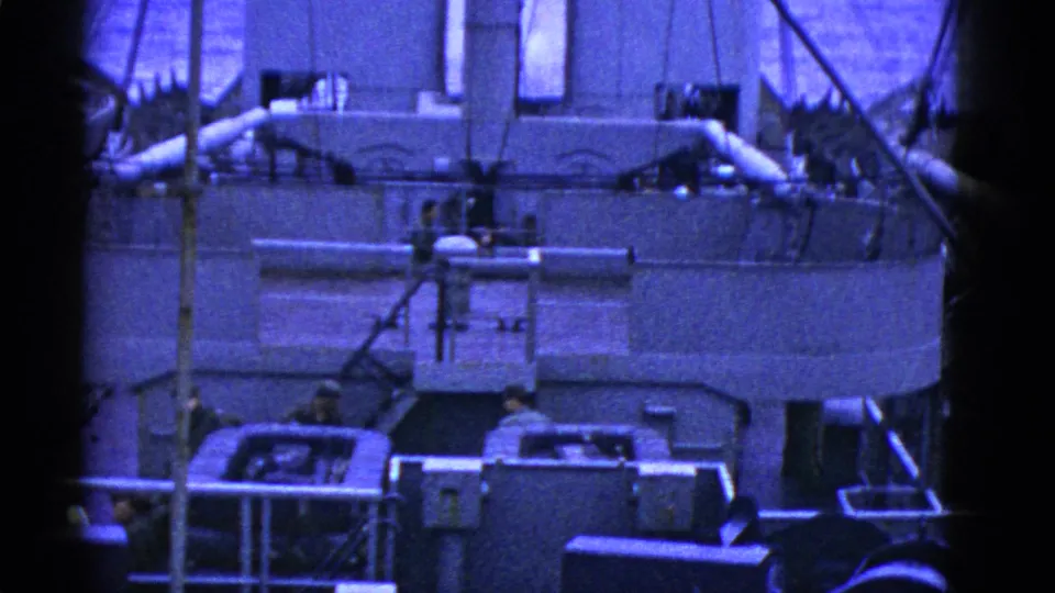 1950s San Francisco naval or maritime deck scene showing crew near large machinery, railings, pipes, and ship structures in blue-tinted 8mm film.