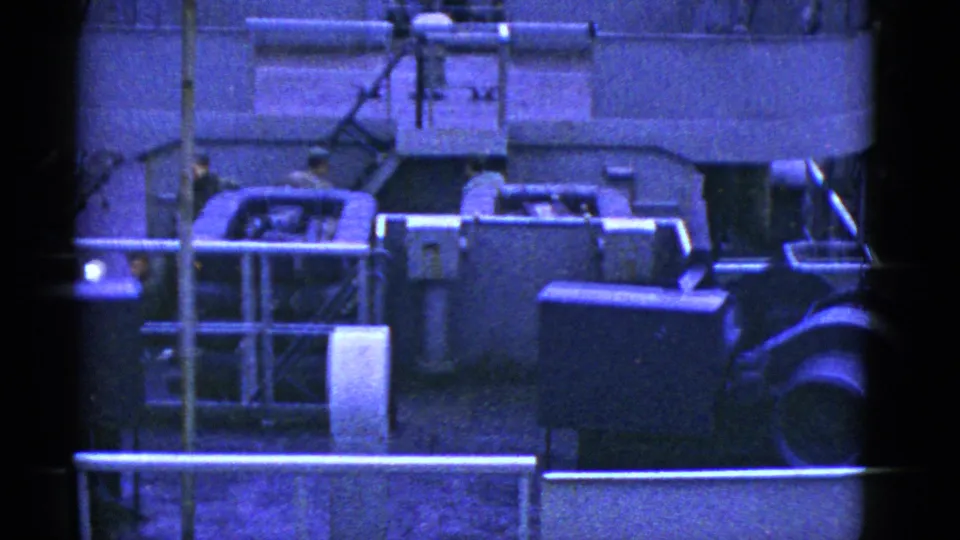 Mid-century shipboard work scene in San Francisco, with crew near a machinery housing, railings, pipes, and deck structures on 8mm film.