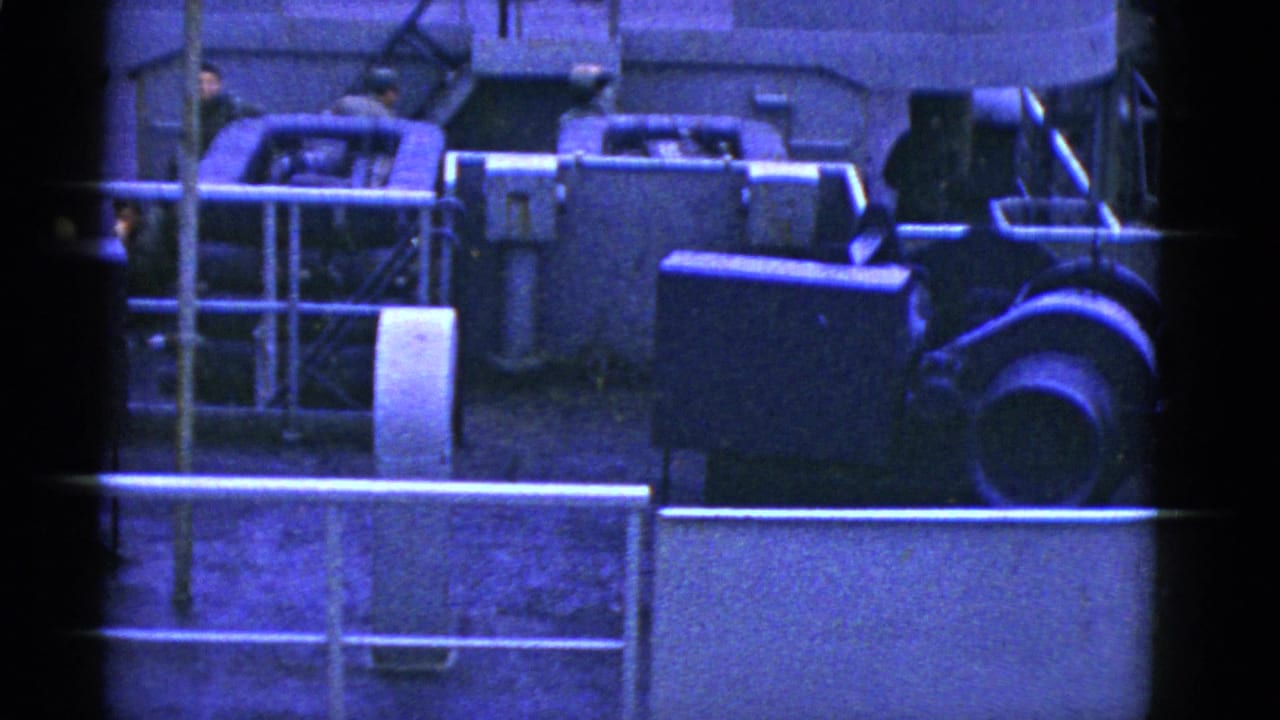 Ship deck machinery and railings above a partial Marine Adder name panel.