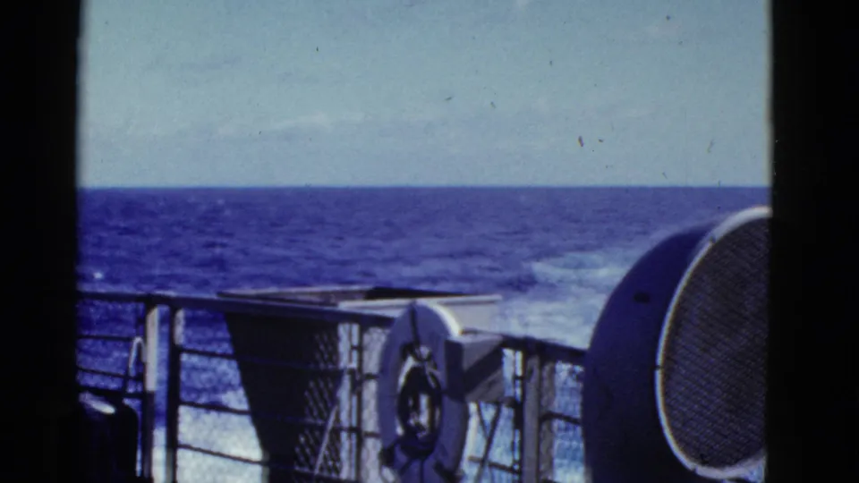 1952 8mm home-movie frame showing a ship railing, deck equipment, wake, and open ocean near the supplied San Francisco context.