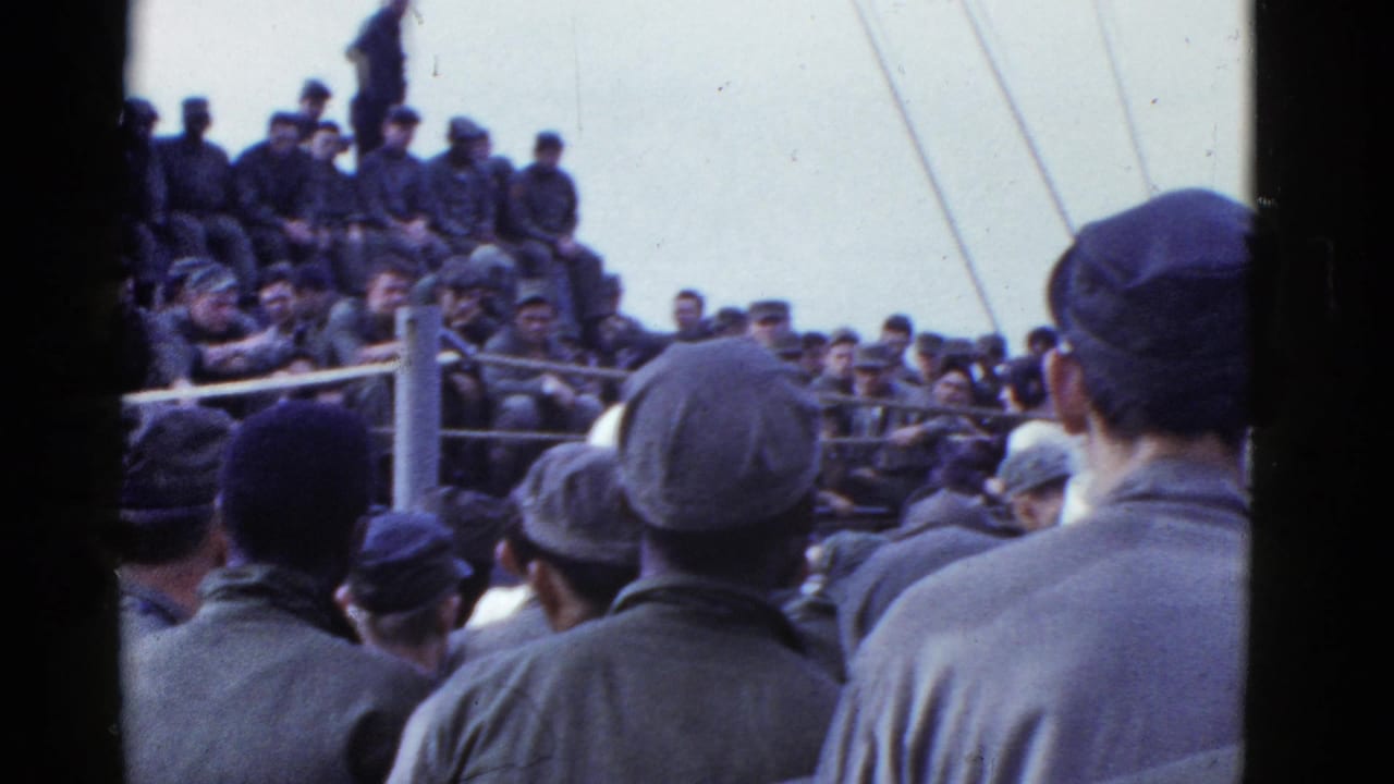 Crowd of servicemen surrounds a roped boxing area on deck.