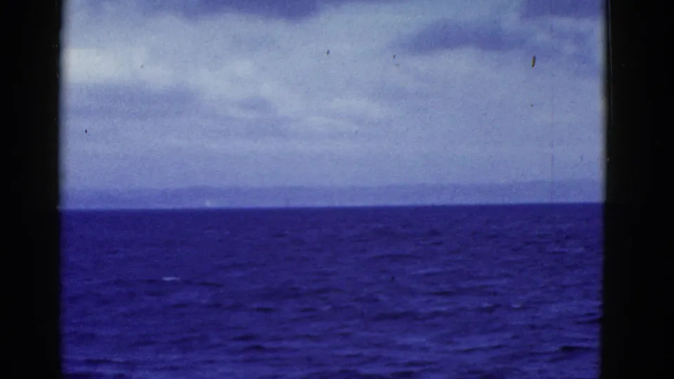 The final frame holds on open ocean, faint land, and clouded sky from a moving vessel in 1952 San Francisco-area footage.