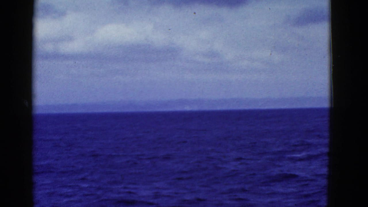 Open blue water and overcast sky divided by a dark vertical bar near the center.
