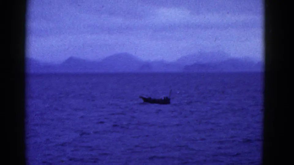 A small boat sits near the lower frame on blue water, with hazy hills behind it in 1952 San Francisco-area footage.