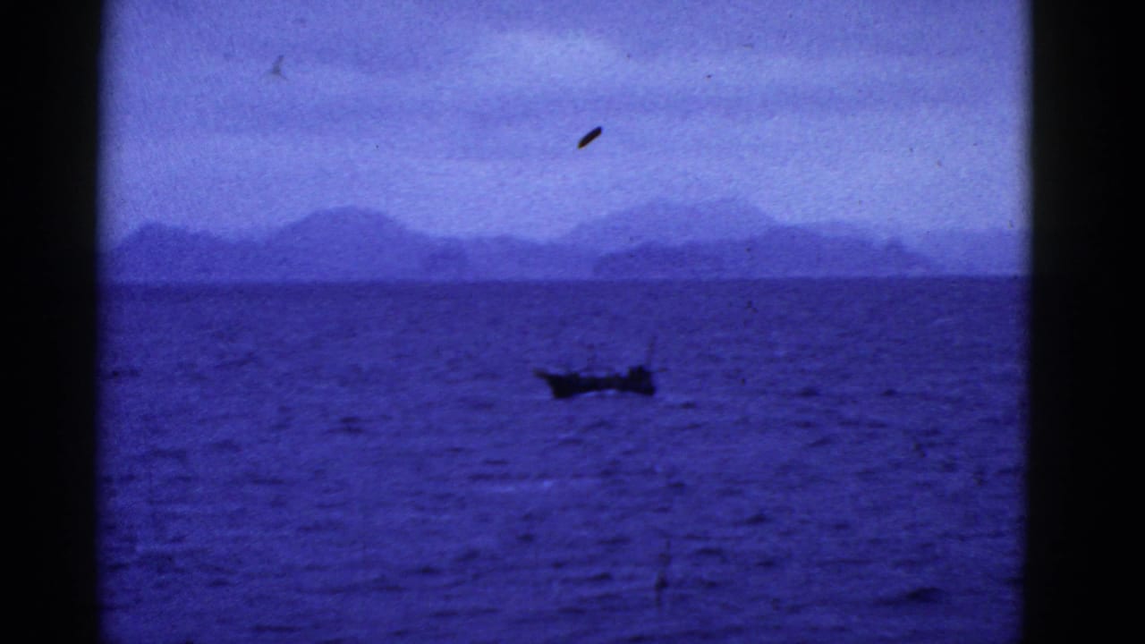 1950s 8mm footage from the San Francisco area appears to show a small boat on open blue water with distant mountain silhouettes.