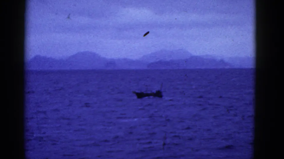1950s 8mm footage from the San Francisco area appears to show a small boat on open blue water with distant mountain silhouettes.