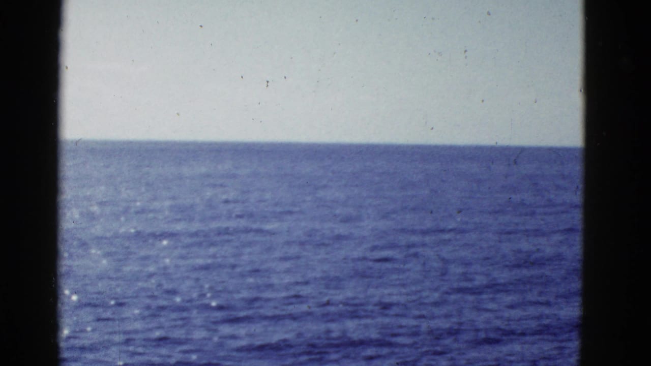 Open blue water under a pale sky, bordered by dark vertical frame edges.
