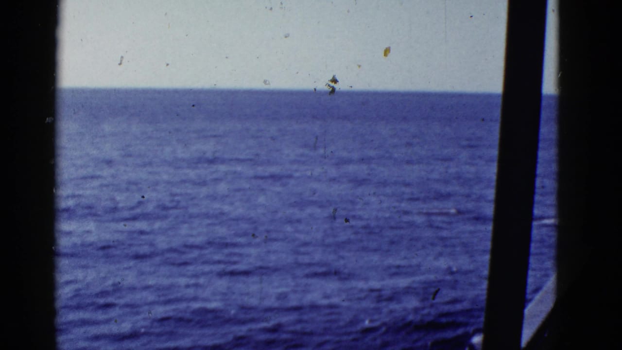 1950s 8mm view of blue ocean and horizon near San Francisco, framed by dark ship window or railing silhouettes.