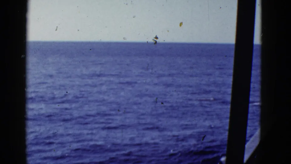 1950s 8mm view of blue ocean and horizon near San Francisco, framed by dark ship window or railing silhouettes.