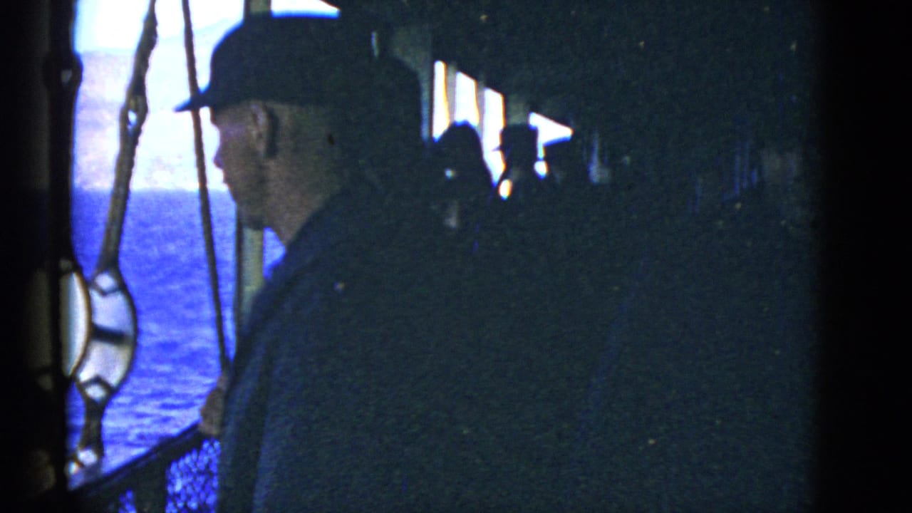Man in profile on a shaded vessel deck with ocean visible through rigging.