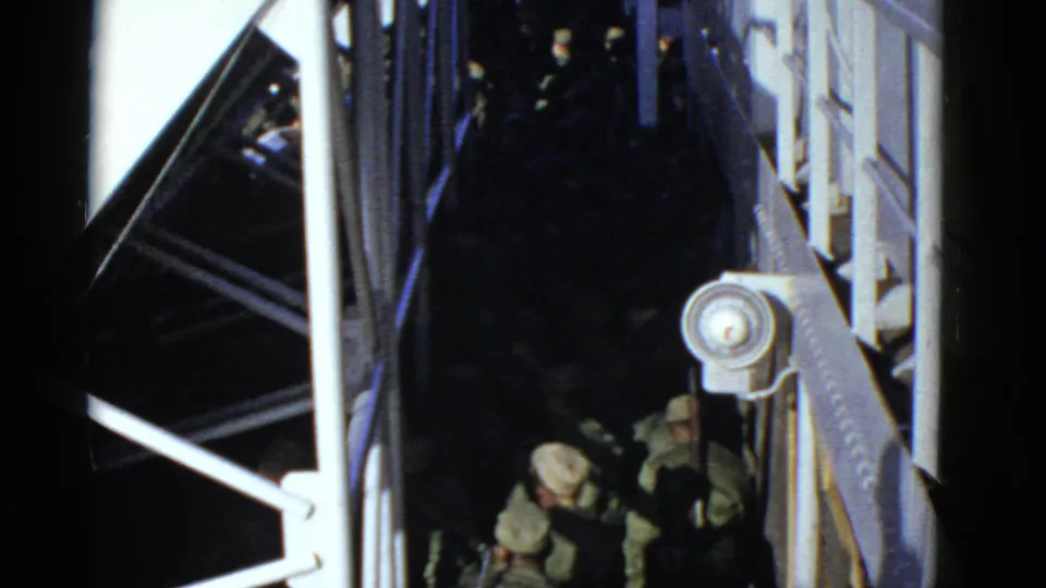Early 1950s San Francisco frame of soldiers passing through a dim passage under a stepped metal structure.