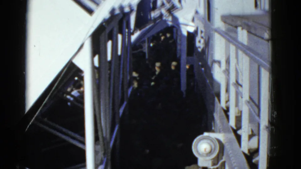 Early 1950s San Francisco frame showing soldiers clustered in darkness below white railings and structural beams.