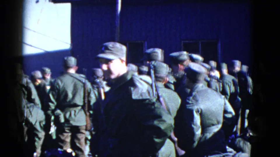 Handheld 8mm view of uniformed soldiers in San Francisco, with one man facing camera amid a group carrying gear.