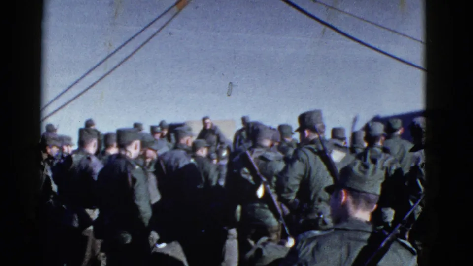 Uniformed men wait close together near a large vessel in 1952 San Francisco archival 8mm footage.
