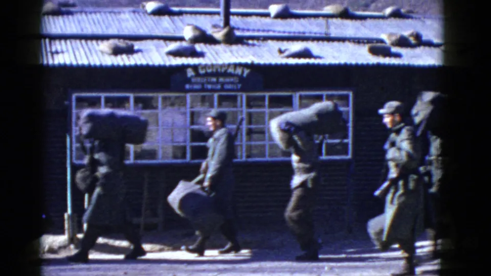 Uniformed military personnel in San Francisco walk with gear past a building sign reading A Company.