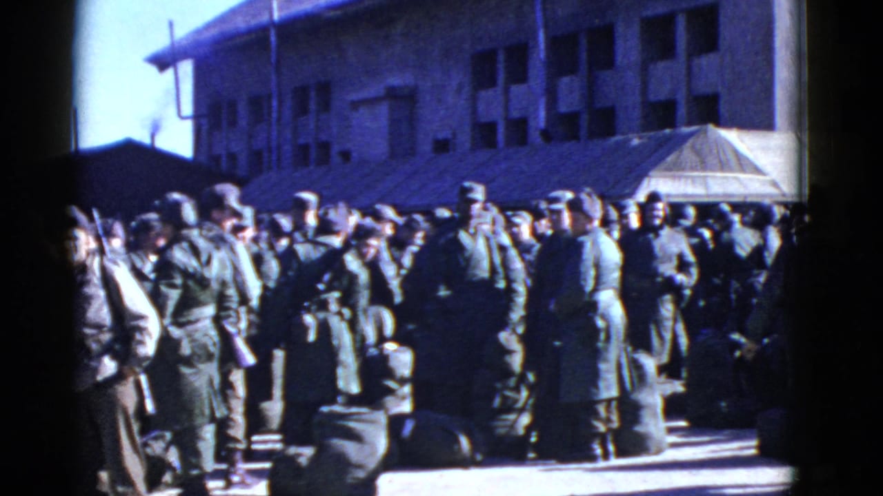 Uniformed soldiers gather with duffel bags outside an institutional building in the San Francisco military setting.