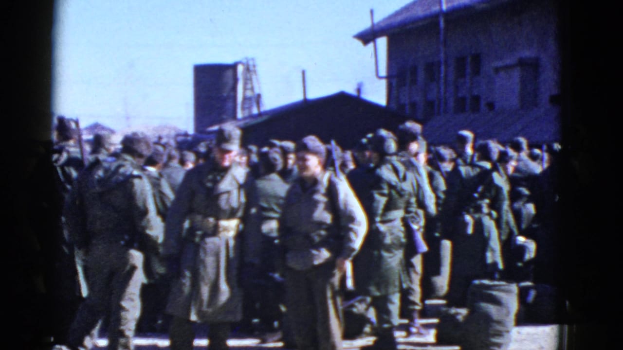 Uniformed soldiers gather outdoors near urban buildings.