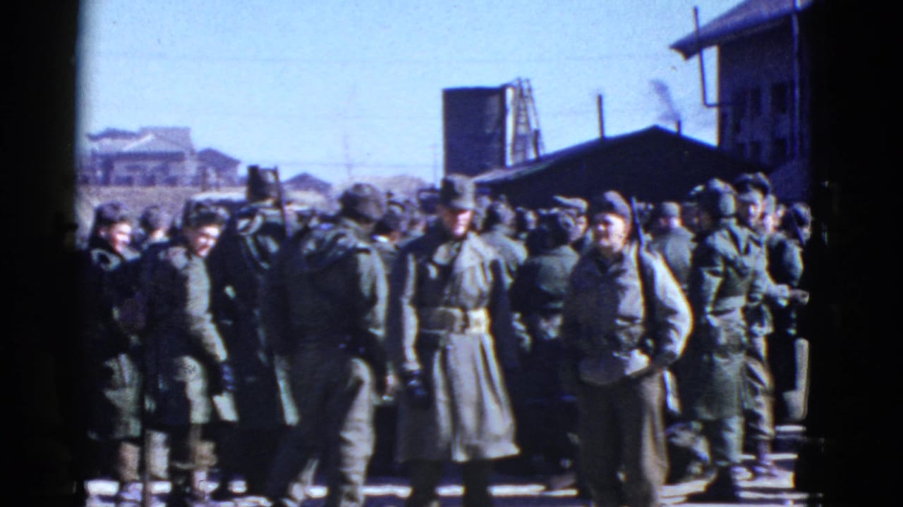 U.S. soldiers appear gathered in an outdoor urban area, with helmets, coats, and nearby structures visible.