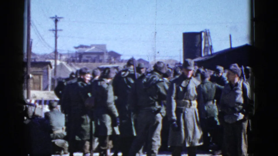 The frame shows uniformed U.S. soldiers gathered near utility poles and low buildings in the stated San Francisco setting.
