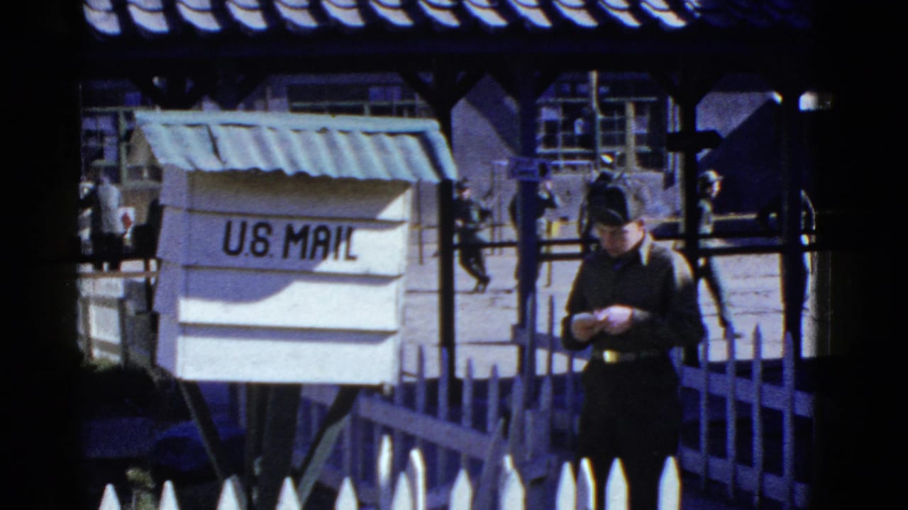 In supported 1950s San Francisco base footage, a uniformed soldier stands by a U.S. Mail box with other soldiers walking in the background.