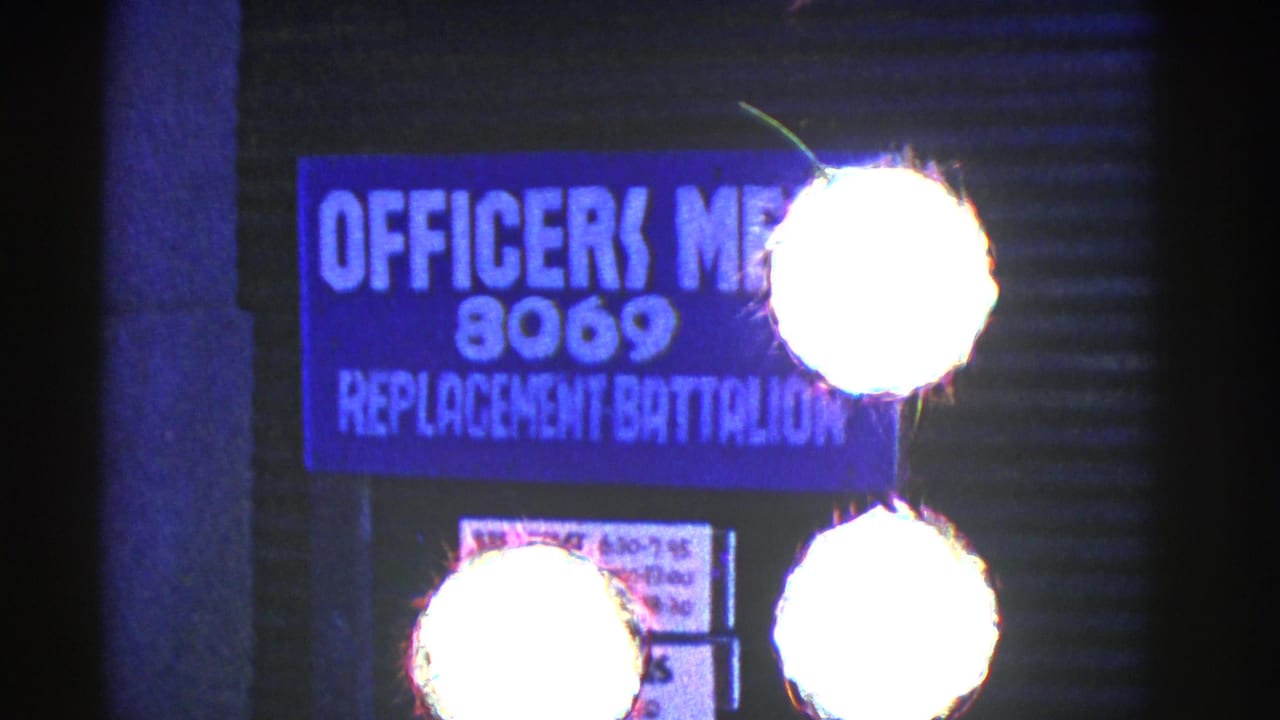 Officers Mess sign for 8069 Replacement Battalion beside a dark building wall.