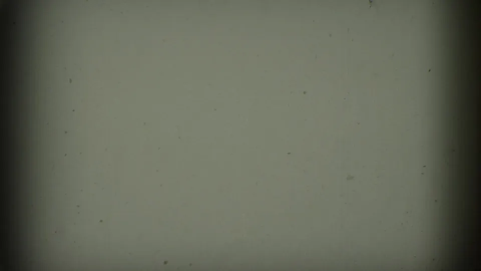 Blank or transitional 8mm frame with greenish exposure, darkened borders, dust, and slight vertical shadowing.