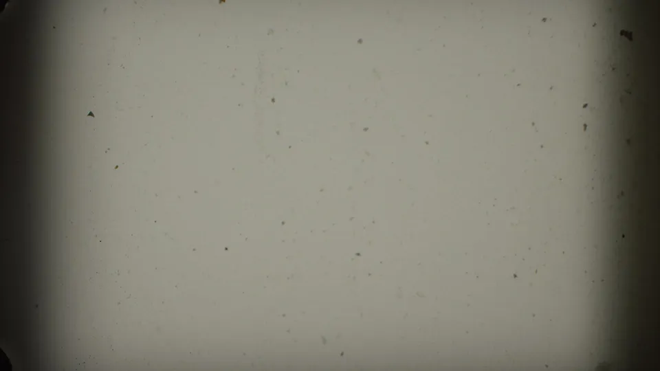 A mostly blank 8mm frame area with visible dust, soft exposure, and dark film borders before the desert view appears.