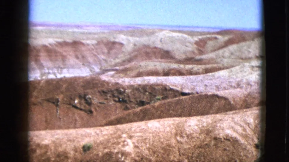 1953 California 8mm view of pale rocky slopes and reddish dry hills in an open arid landscape.